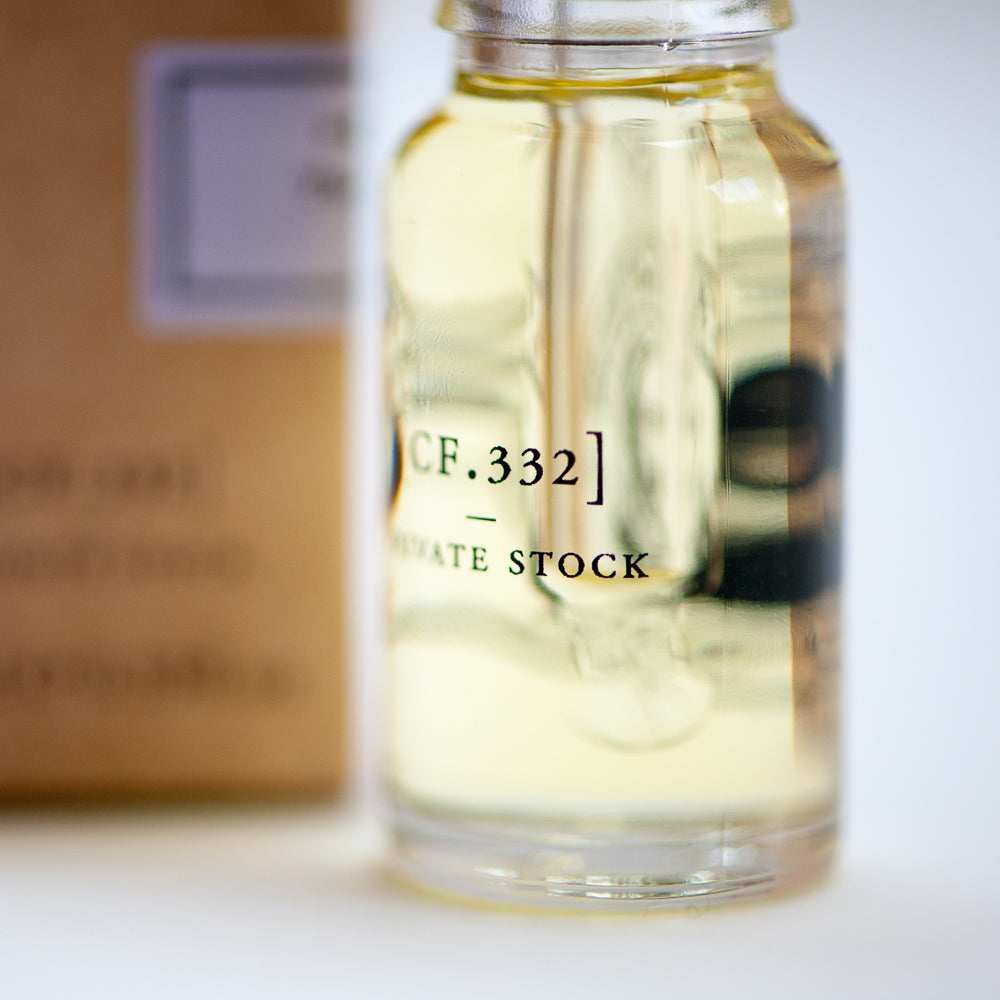 Glass bottle with a label reading 'CF.332 PRIVATE STOCK' on a white background