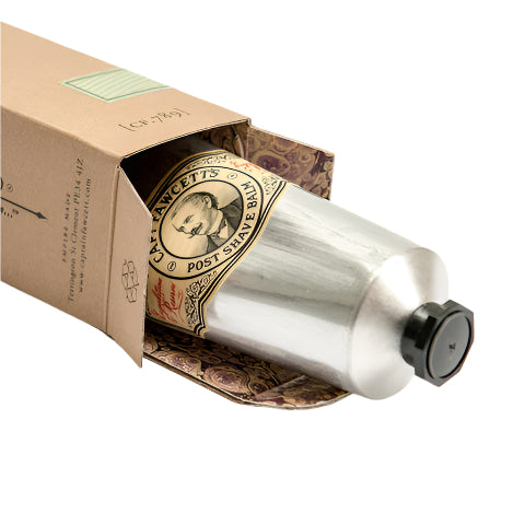 Silver tube of balm with a decorative label on a white background