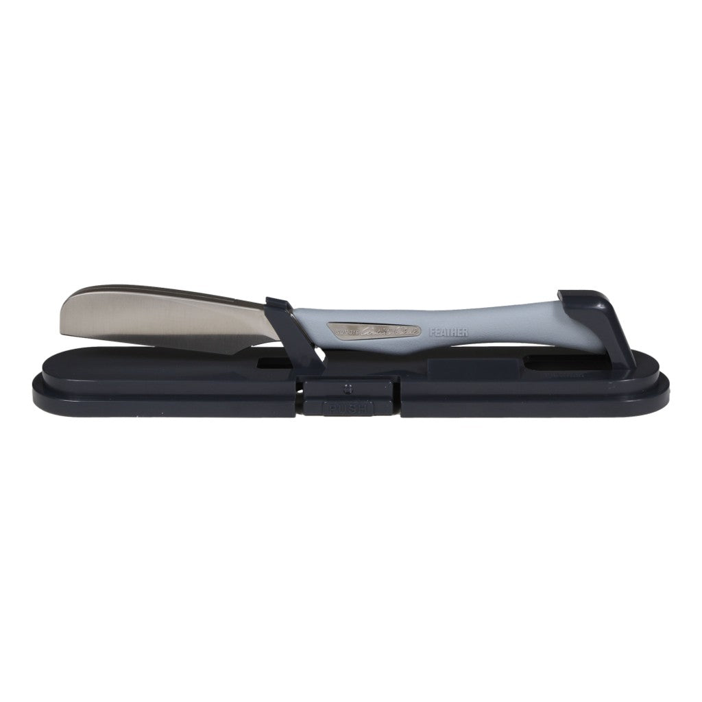 Feather Artist Club DX Japanese Straight Razor securely placed in its protective case, showcasing the soft grip handle and stainless steel head."
