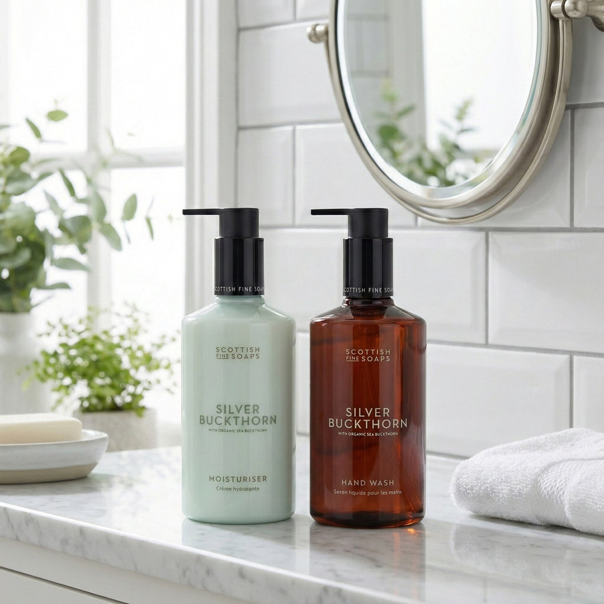 Silver Buckthorn hand wash and moisturiser pump bottles beside a bathroom mirror