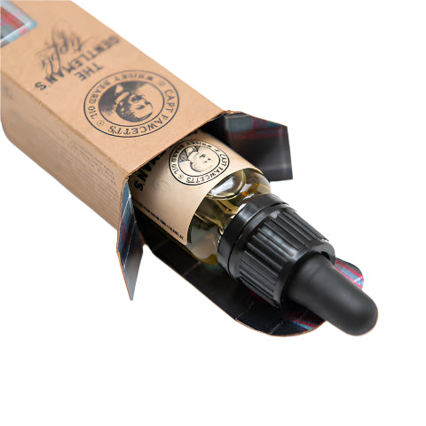 Bottle of beard oil with cap and packaging on a white background