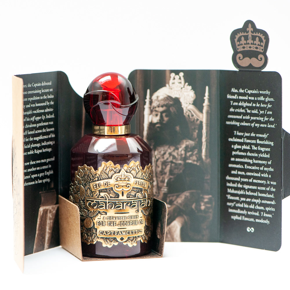 Perfume bottle with gold label in an open box featuring a historical image and text.