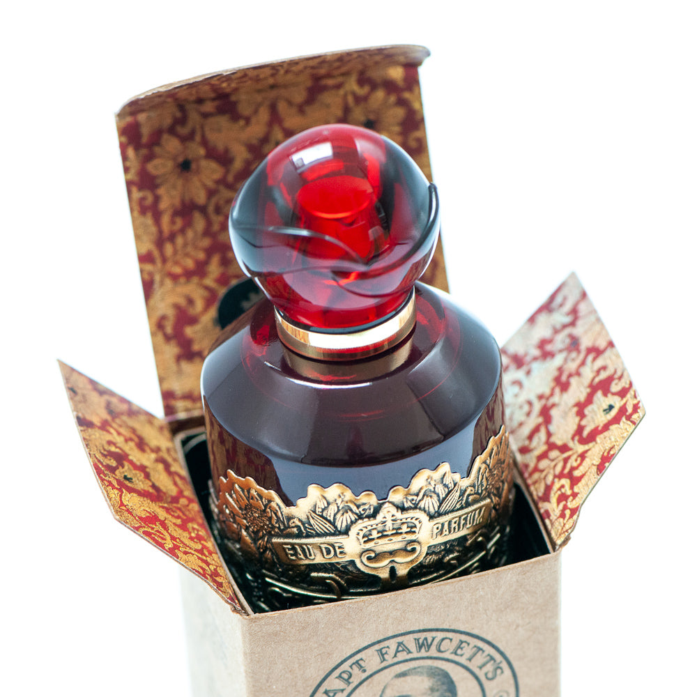 Bottle with red cap and gold accents in a decorative box