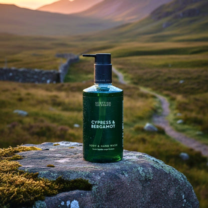 Green Cypress & Bergamot Body & Hand Wash bottle on a mossy rock in a mountain landscape