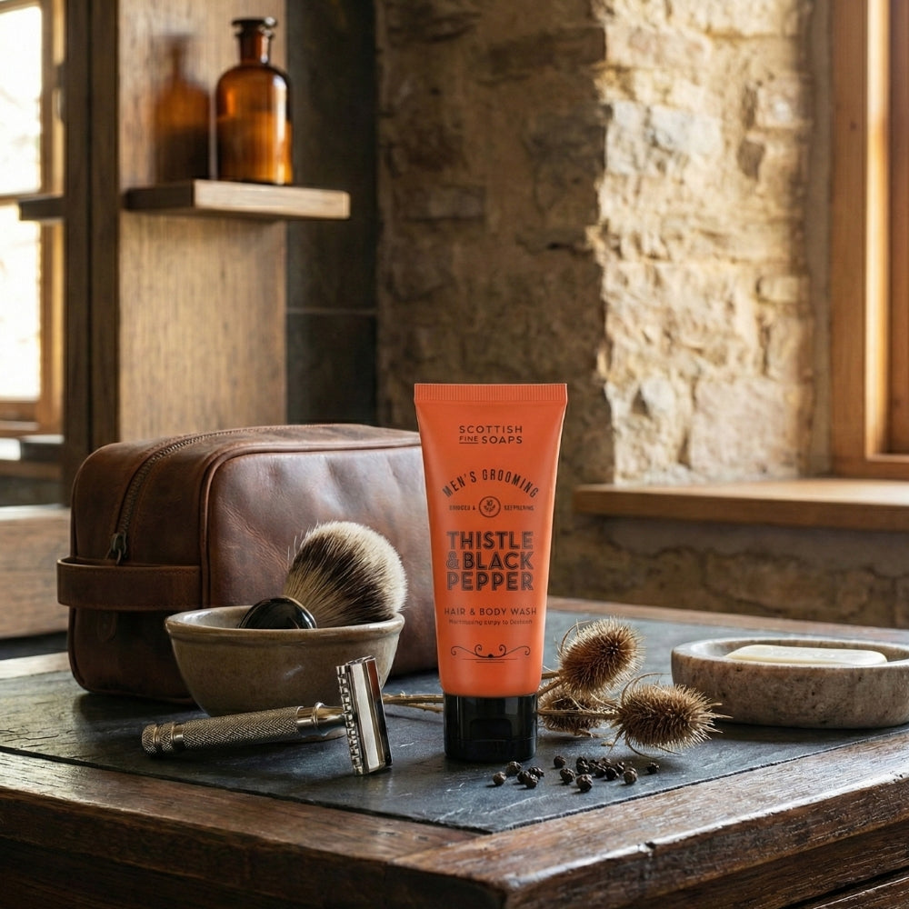 Thistle & Black Pepper Hair & Body Wash beside a wash bowl, towel and shaving brush