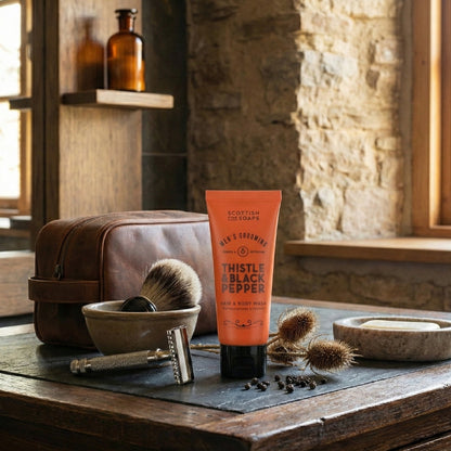 Thistle & Black Pepper Hair & Body Wash beside a wash bowl, towel and shaving brush