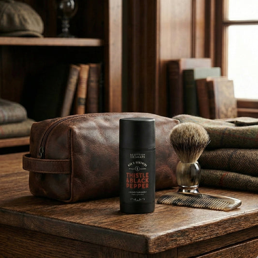 Black Thistle & Black Pepper Moisturiser bottle on a wooden table with a shaving brush
