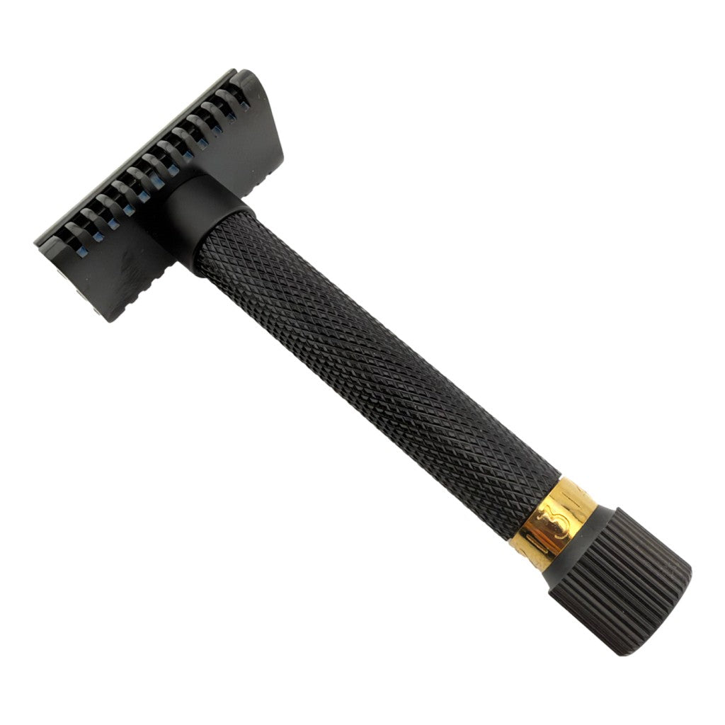 A black safety razor with a textured handle and a gold accent ring near the end, shown on a plain white background.