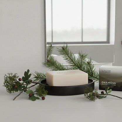 Oakmoss soap and its box beside a bathroom window with pine sprigs
