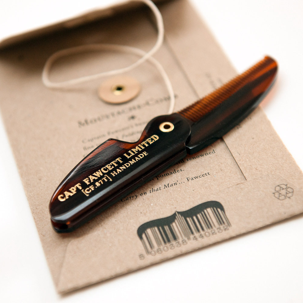 Folding comb with 'Capt Fawcett Limited' branding on a branded box.
