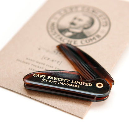 Handmade comb with 'Capt Fawcett Limited' branding on a beige background