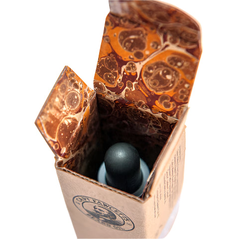Marbled brown packaging with a black sphere inside on a white background