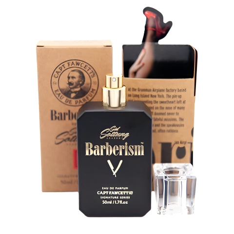 Black perfume bottle labeled 'Barberism' with a gold cap, next to a cardboard box featuring a man's face.