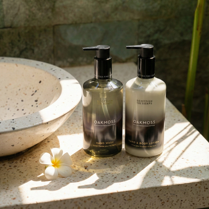 Oakmoss hand wash and lotion pump bottles beside a sunlit basin