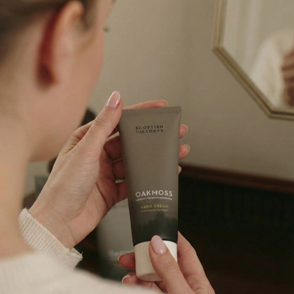 Person applying Oakmoss Hand Cream while holding the tube