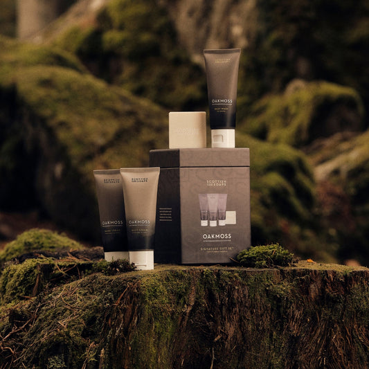 Oakmoss Signature Gift Set arranged on a moss-covered tree stump