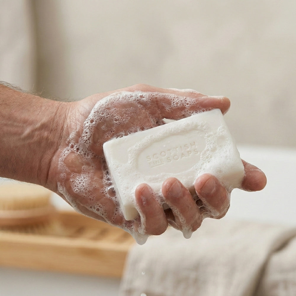 Thistle & Black Pepper soap bar creating lather in a hand