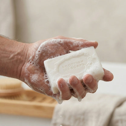 Thistle & Black Pepper soap bar creating lather in a hand