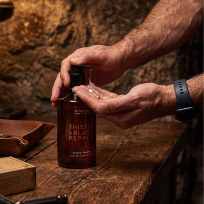 Hands dispensing Thistle & Black Pepper Hand Wash from its pump bottle