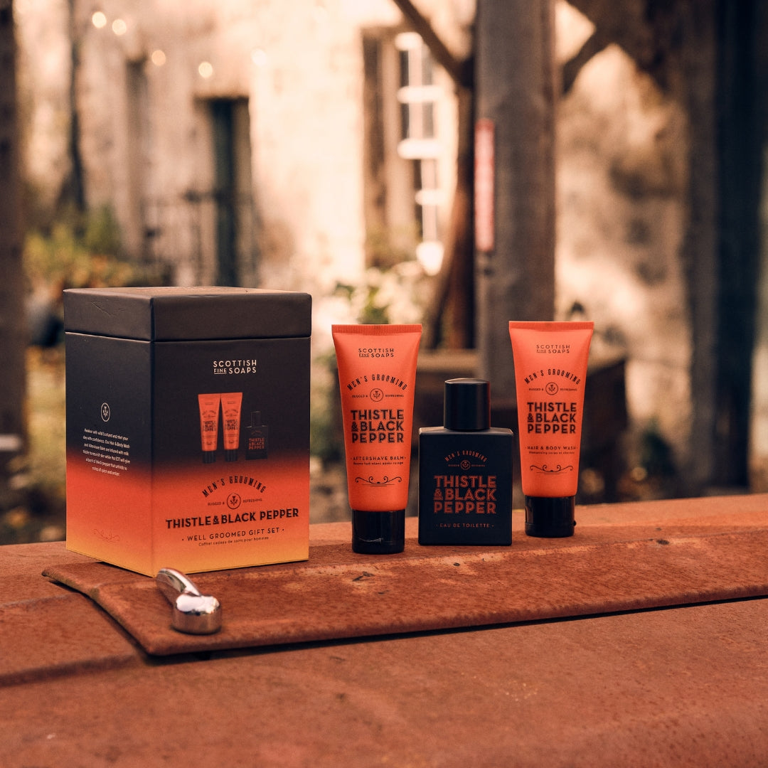 Thistle & Black Pepper Well Groomed Gift Set with fragrance, wash and balm on a shelf