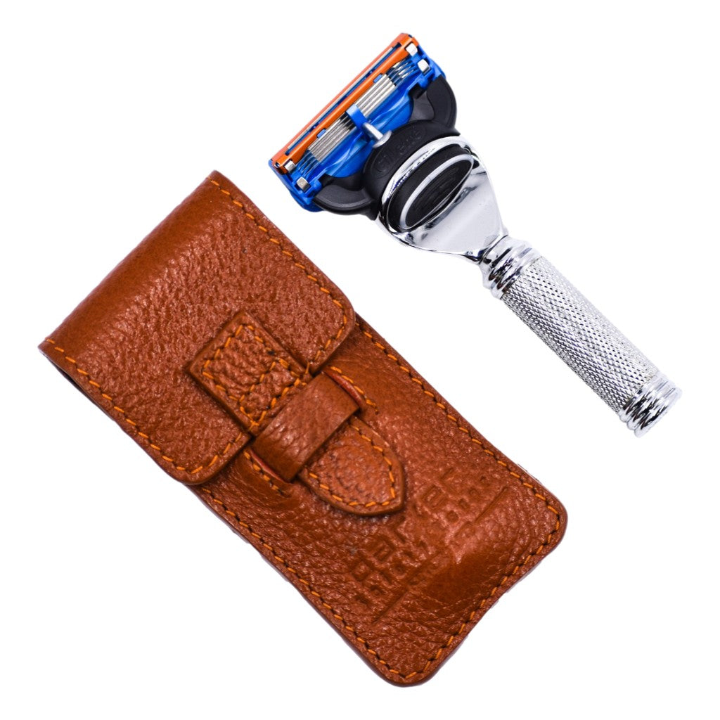 Shaving razor with brown leather case on a white background