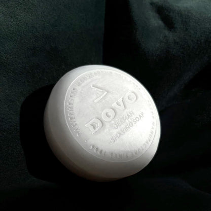 White shaving soap bar with 'Dovo' branding on a dark background