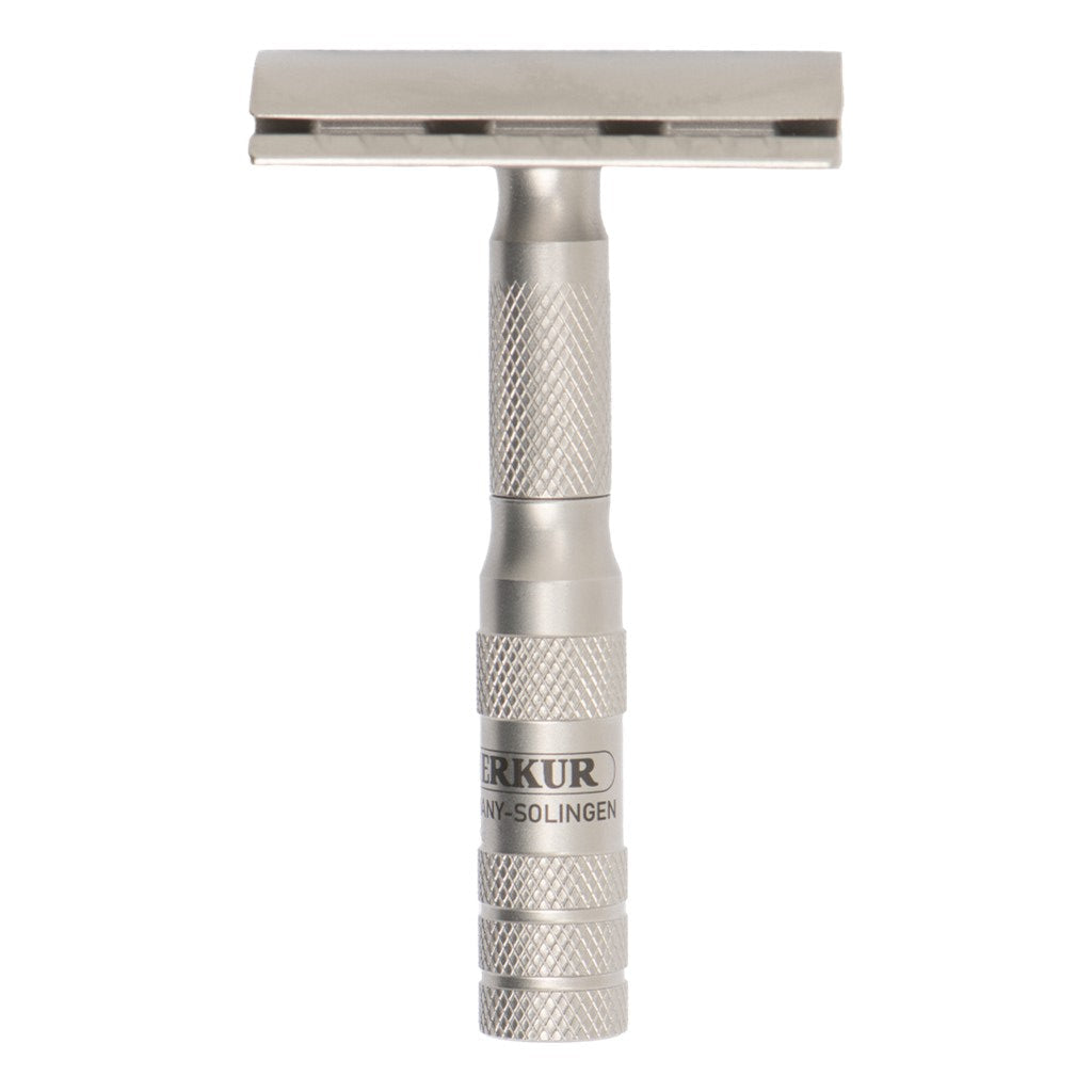 A silver metal safety razor with a textured knurled handle and a rectangular head, featuring the brand name 'MERKUR' printed on the side, set against a plain white background.