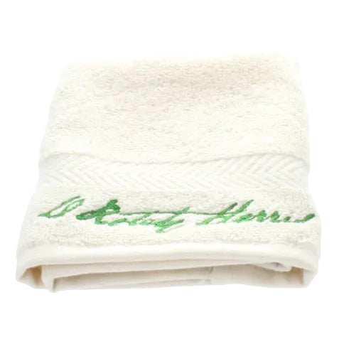 White towel with green embroidery on a white background