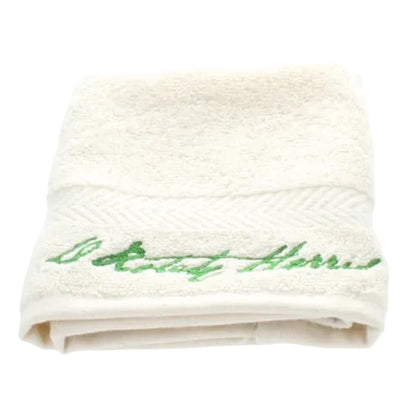 White towel with green embroidery on a white background