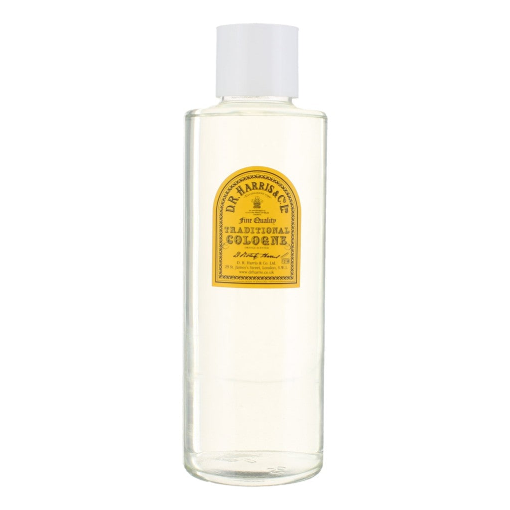 Clear bottle of traditional cologne with a yellow label on a white background