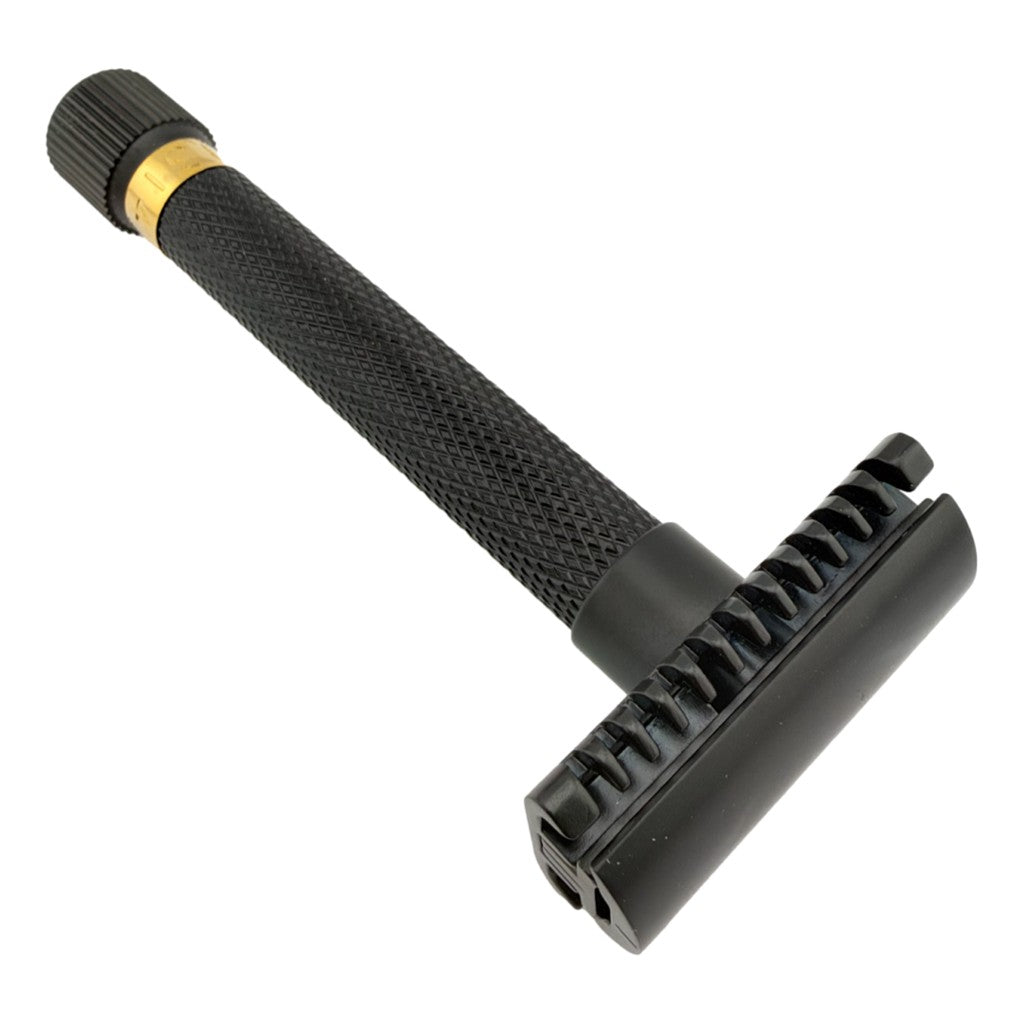A black safety razor with a textured handle, a gold accent ring near the cap, and a black guard on the handle head, shown on a plain white background.